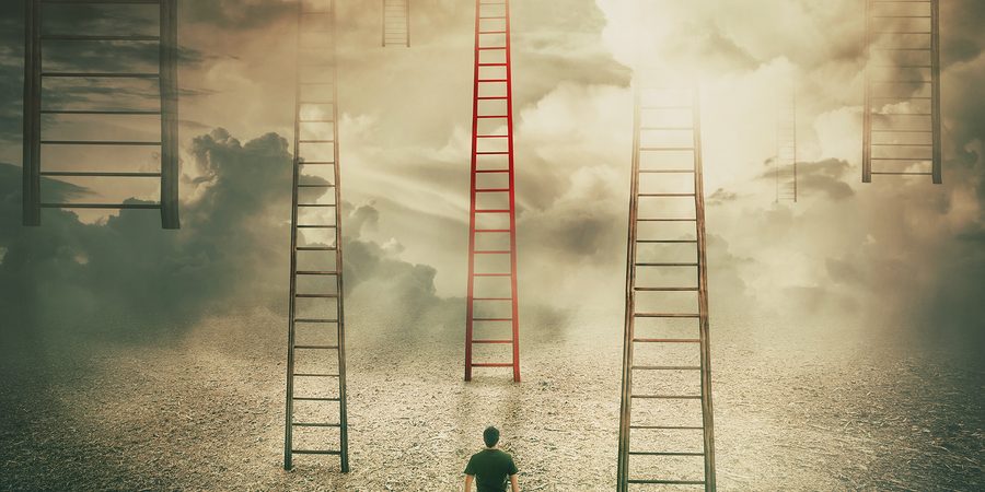 Man Standing In Front Of Huge Ladders Going Up To The Sky. Choos