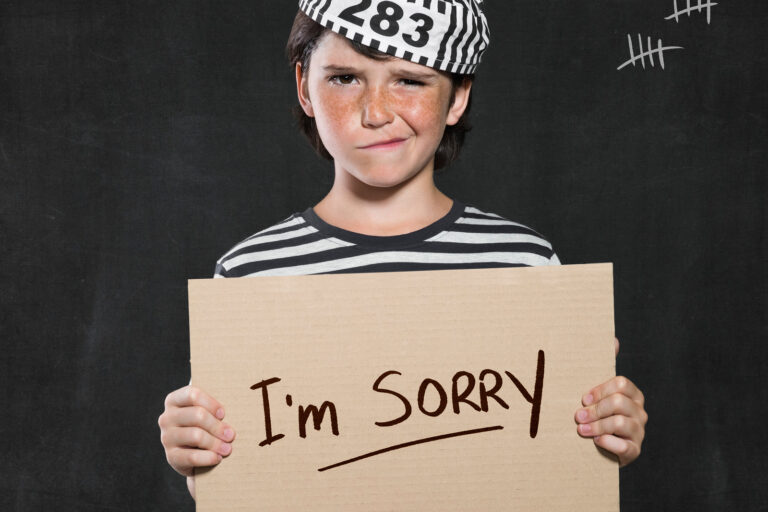 Closeup mugshot photo of boy holding I’m sorry sign. Young boy m