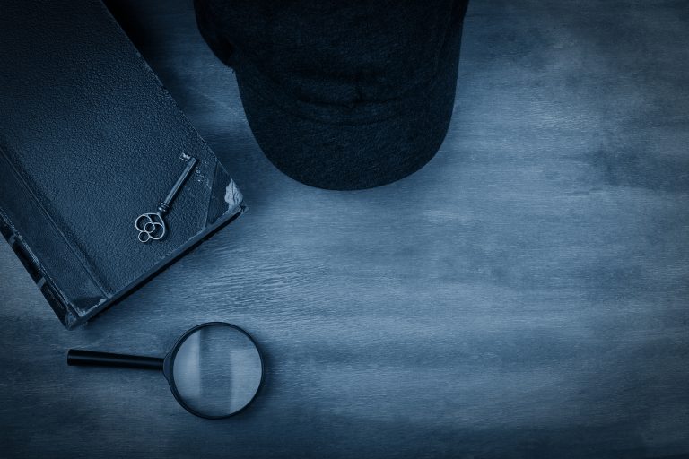 Old Book, A Key, A Detective Cap And A Magnifying Glass Against